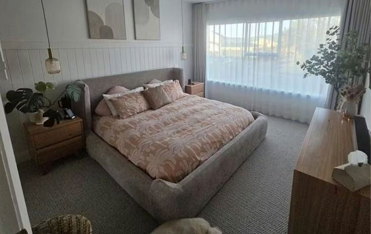 Neatly made bed in a bedroom with decor elements.